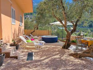 a patio with chairs and a table and a tree at Holiday Home Mario-1 by Interhome in Makarska