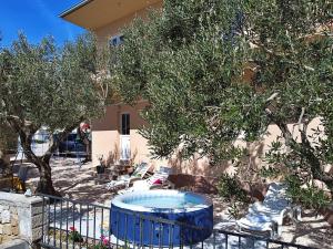 a yard with chairs and a tree and a pool at Holiday Home Mario-1 by Interhome in Makarska