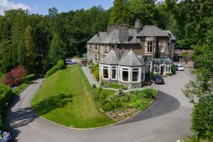 an estate with a large house with a green lawn at Merewood Country House Hotel in Windermere
