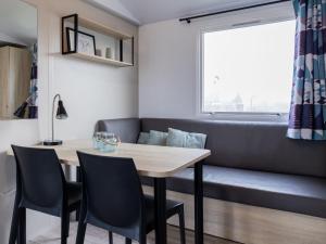 a dining room with a table and chairs and a couch at Holiday Home Natuurlijk de Veenhoop by Interhome in De Veenhoop