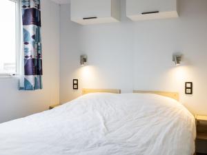 a bedroom with a large bed with white sheets at Holiday Home Natuurlijk de Veenhoop by Interhome in De Veenhoop