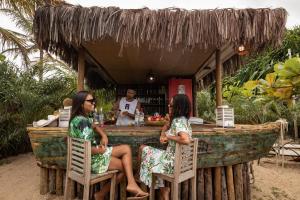 a group of three women sitting at a bar at Pousada Colmeia - Praia de Santo André, Bahia in Santo André
