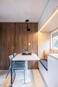 a small dining room with a white table and chairs at Holiday Home Natuurlijk de Veenhoop by Interhome in De Veenhoop