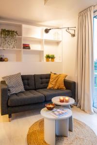 a living room with a couch and a table at Holiday Home Natuurlijk de Veenhoop by Interhome in De Veenhoop