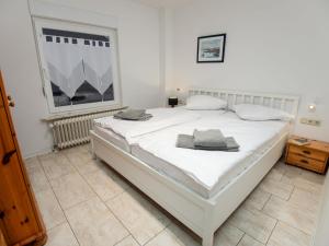 Cama blanca en habitación con ventana en Apartment Backbord by Interhome, en Norddeich