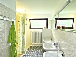 a bathroom with two sinks and two mirrors at Holiday Home Runnimoos-3 by Interhome in Laterns