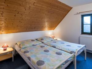 ein Schlafzimmer mit einem Bett und einer Holzdecke in der Unterkunft Holiday Home Holiday Hill 32 by Interhome in Lauterwasser