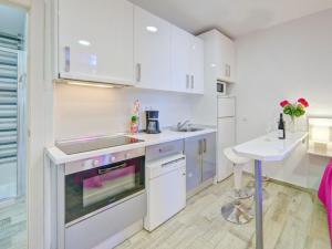 cocina con armarios blancos, fregadero y mesa en Studio Muralla Roja-3 by Interhome, en Calpe