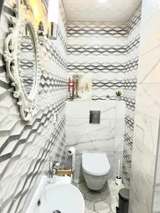a bathroom with a white toilet and a sink at Nataly New luxury apartment on Black sea in Varna City +14 photos