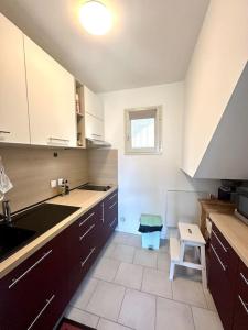 una cocina con fregadero y taburete. en Appartement vue mer 5 personnes, en LʼÎle-Rousse