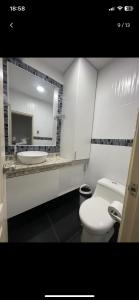 a bathroom with a white toilet and a sink at Departamento amplio para familias in Guayaquil