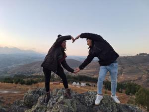 two people standing on top of a mountain holding hands at GLAMPING NAKAMA Cajamarca in Cajamarca