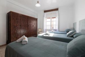 1 dormitorio con 2 camas y ventana en Casa Margarita, en Cañete la Real