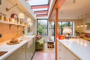 uma cozinha com um lavatório e uma sala de estar em Ravenscourt - Stylish home by the sea em Whitstable