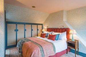 a bedroom with a large bed with a red headboard at Ravenscourt - Stylish home by the sea in Whitstable