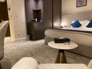 una camera d'albergo con un letto e un tavolo di فندق سافوي جدة Savoye Hotel a Gedda