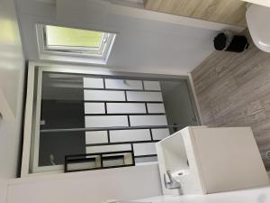 a bathroom with a mirror and a sink and a window at Holiday Home Natuurlijk de Veenhoop by Interhome in De Veenhoop