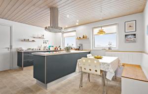 a kitchen with a blue island and a table at 3 Bedroom Pet Friendly Home In Ulfborg in Ulfborg