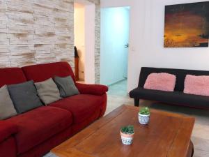 een woonkamer met een rode bank en een salontafel bij Apartment Les Chênes by Interhome in Gassin