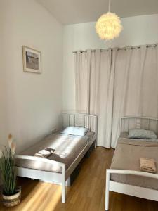 two beds in a room with a chandelier at Apartment Olivia - Old Town, AC in Bratislava