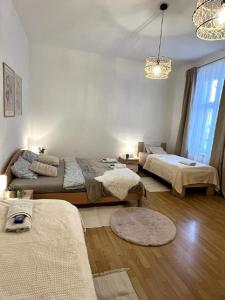 a living room with two beds and a chandelier at Apartment Olivia - Old Town, AC in Bratislava