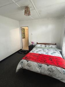 a bedroom with a large bed with a red blanket at Reading holiday home in Nuwara Eliya
