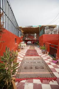 a courtyard of a house with red walls and a tile floor at Riad Fez Hostel in Fès