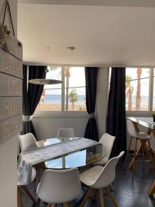 a dining room with a glass table and white chairs at Serenity by levante beach (YAGO), 7pax wi-fi A\C in Benidorm