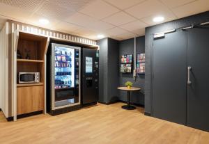 シャティヨンにあるB&B HOTEL Paris Porte de Châtillonの冷蔵庫とテーブルが備わる客室です。