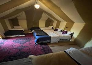 an attic bedroom with two beds in a room at Camel trekkings in Adrouine