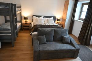 ein Schlafzimmer mit einem Bett, einem Sofa und einem Stuhl in der Unterkunft Nicky in Niederau