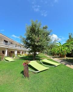 a group of hammocks in the grass next to a building at Residence Costa d’Otranto in Otranto