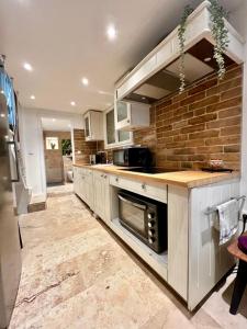 a kitchen with white cabinets and a brick wall at Town house in Cannes city center in Cannes