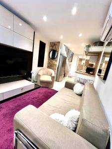 a living room with a couch and a flat screen tv at Town house in Cannes city center in Cannes