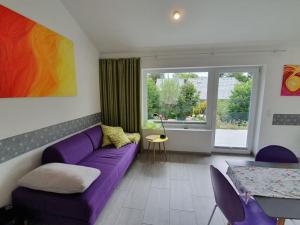 a living room with a purple couch and a table at Das Ferienhaus mit lichtem 85m² Studio in Herrischried