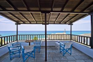 - une terrasse couverte avec des chaises et une table donnant sur l'océan dans l'établissement Flamingo Hotel Pelion - Seaside Superior Studios & Suites, à Chorefto