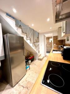 uma cozinha com um frigorífico de aço inoxidável e escadas em Town house in Cannes city center em Cannes