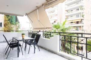 balcone con tavolo e sedie di Faliro Sunlit 3BR Apartment by UPSTREET ad Atene