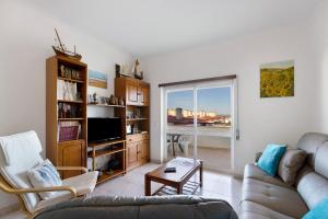 Una sala de estar con un sofá y un televisor. en Lagos Ocean View Apartment, en Lagos