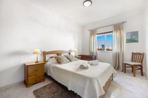 ラゴスにあるLagos Ocean View Apartmentのベッドと椅子と窓のある寝室