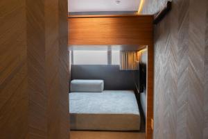 una piccola camera con un piccolo letto in una stanza di ピンポンホテル&キャビン pin pon hotel & cabin a Shunan