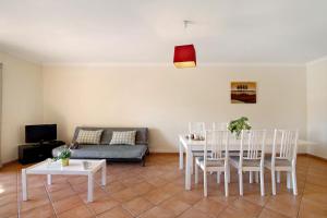 a living room with a table and chairs and a couch at Apartamento T3 Santa Luzia - H in Santa Luzia