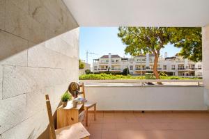 a patio with a table and chairs and a tree at Apartamento T3 Santa Luzia - H in Santa Luzia