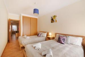 a bedroom with two beds with towels on them at Apartamento T3 Santa Luzia - H in Santa Luzia