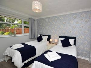 - 2 lits dans une chambre avec du papier peint bleu dans l'établissement 2 Bed in Bournemouth 78541, à Ferndown