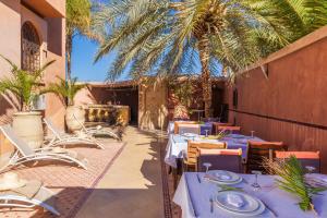 マラケシュにあるRiad Ushuaia La Villa - Centre Marrakechの青いテーブルと椅子、ヤシの木があるレストラン