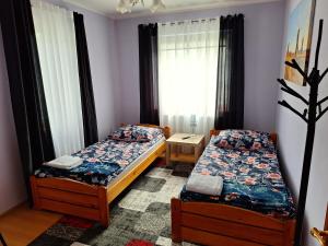 1 dormitorio con 2 camas y ventana en Cichy zakątek, en Naniec