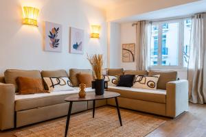 a living room with a couch and a table at SERRENDY Apartment with terrace & sea view in Cannes