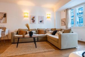a living room with a couch and a table at SERRENDY Apartment with terrace & sea view in Cannes