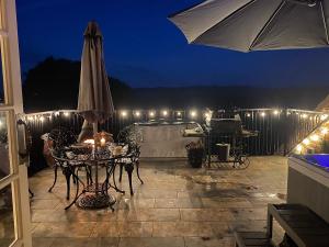 a patio with an umbrella and a table with lights at Burtree Country House and Retreat in Thirsk